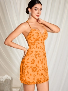 Détails de la mini robe orange à paillettes avec broderie florale et décolleté en V plongeant