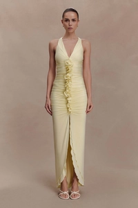 Detail of light yellow halter dress featuring elegant ruffles and a side leg slit