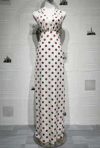 Detailed view of cream maxi dress with red polka dots featuring a halter neck and V-neckline