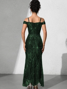 Detail of emerald green sequin evening gown with intricate geometric patterns and cold-shoulder