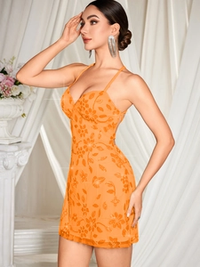 Détail de broderies florales à paillettes orange sur une mini robe dos nu avec tulle chic