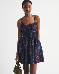 Detail of navy sleeveless dress featuring strawberry print and ruffled strap neckline