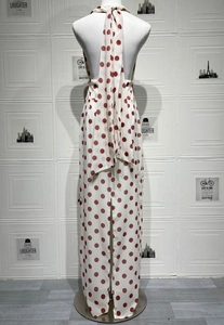 Detail of white backless dress with large red polka dots and decorative long neck ties