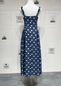 Detail of adjustable straps and smocked back on navy blue polka dot maxi dress
