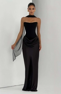 Detail of elegant black satin evening gown featuring waist draping and mesh neck scarf