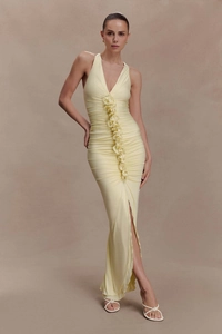 Detail of elegant light yellow bodycon dress with ruffled pleated trim and high side slit