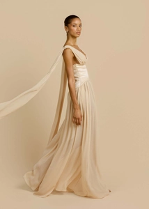 Dettaglio di abito in chiffon beige con scollo a V e nappe fluenti sulle spalle