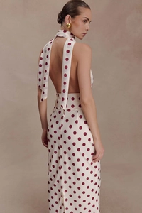 Close-up of elegant halter neckline with long ribbons on a white polka dot backless maxi dress