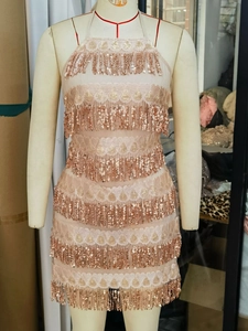 Détail d'une robe rose à sequins et franges avec col licou et broderies de franges superposées
