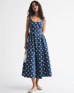 Detail view of a vintage blue sleeveless midi dress with white polka dot print design