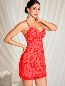 Détail de broderie florale à paillettes rouges et fines bretelles sur robe de soirée