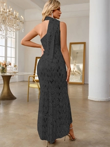Detail of elegant black sequin evening gown featuring a one-shoulder cut and long ribbon