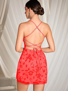 Détail de la mini-robe rouge corail avec broderie florale pailletée et texture dentelle