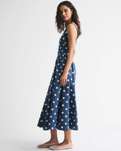Detail view of navy blue polka dot sleeveless maxi dress with flared hem and slim waist