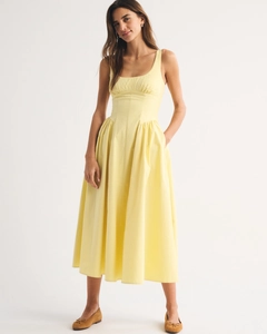 Detail of square neck sleeveless yellow dress with pleated bust and elegant A-line cut