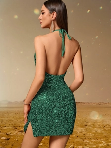 Détail de la mini-robe verte à paillettes avec dos nu et col licou à la lumière du soleil