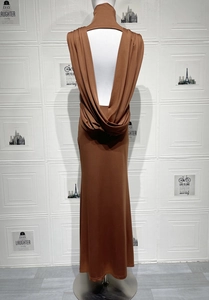 Détail d'une robe longue dos nu marron avec un élégant design drapé en cascade à l'arrière