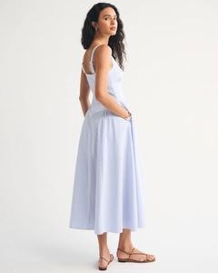 Detail view of adjustable buckle straps and pocket on a blue striped A-line midi dress