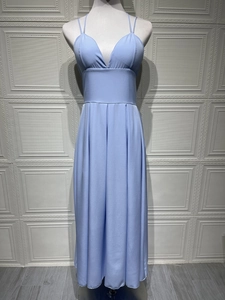 Détail d'une robe bleu clair à bretelles avec col en V profond et taille plissée