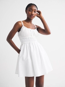 Sleeveless white floral short sun dress with smocked bodice and ruffled neckline detail