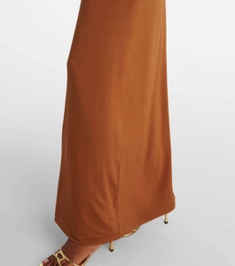Détail de l'ourlet de la robe en maille caramel avec des sandales dorées à talons hauts