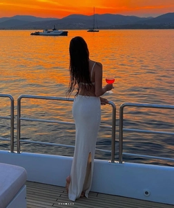 Detail view of white ribbed knit maxi skirt with side slit on yacht deck at sunset
