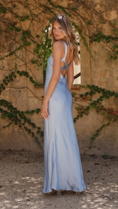Detail of light blue satin dress featuring cross back straps and slim fit silhouette