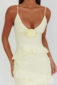 Detail of light yellow backless dress featuring a handcrafted 3D flower on the V-neckline