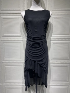 Detail view of the black sleeveless dress featuring ruched layers and asymmetrical hemline
