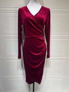 Detail eines weinroten Samtkleides mit V-Ausschnitt und eleganten Plissee-Falten an der Taille