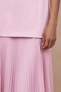 Nahaufnahme des rosa plissierten Maxirocks mit erstklassiger Textur und feinem Stoffdetail
