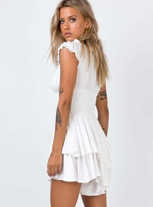 Detail of white Swiss dot mini dress featuring ruffled sleeves and smocked waistline