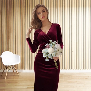 Close-up of elegant burgundy velvet long-sleeved dress with pleated V-neck detail
