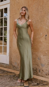 Detailed view of the olive green satin slip dress fabric texture under natural light