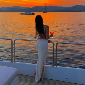 White ribbed knit two-piece set featuring backless crop top and high-waisted side slit skirt
