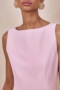 Detailaufnahme des eleganten rosa ärmellosen Kleidausschnitts und der goldene Ohrringe