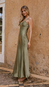 Detail of olive green satin dress with deep V-neck and slim fit silhouette