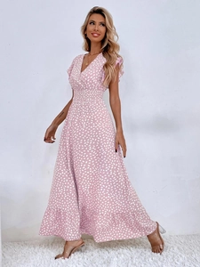 Dettaglio di abito lungo rosa con scollo a V, maniche a balze e vita elastica