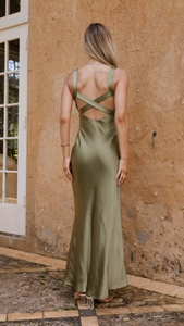 Detail of cross-back straps on an elegant olive green satin maxi dress with a mermaid cut