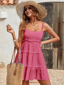 Detail of pink tiered mini dress featuring jacquard polka dots and ruffle hem layers