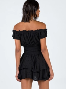 Detail of black off-shoulder dress with Swiss dots, elastic waist and ruffled hem