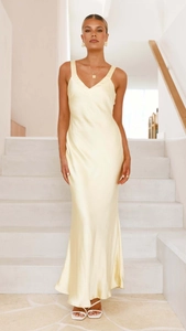 Detailed view of pale yellow satin slip dress fabric texture and elegant V-neck design