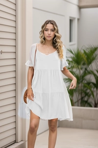Detail of white summer mini dress featuring tiered ruffle hem and elegant V-neckline