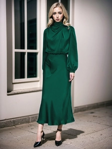 Dettaglio dell'abito lungo in raso verde scuro elegante con collo alto a pieghe e maniche lunghe