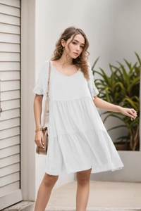 Detailed view of white V-neck tiered mini dress with ruffled sleeves and lightweight fabric