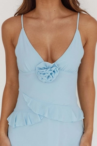 Detailed view of the 3D handcrafted floral decoration and ruffled trim on the blue dress