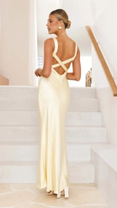 Detail of cross back design on a light yellow satin long dress with elegant drapes