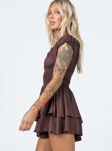 Detail view of brown Swiss dot dress with tiered ruffles and elastic smocked waistline