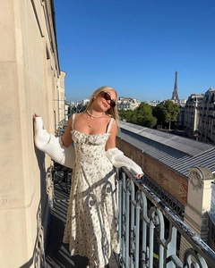 Detail of white floral sundress with drawstring bust on a Parisian balcony view