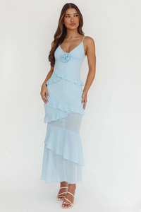 Detailed close-up of blue backless dress with layered ruffles and floral 3D appliqué